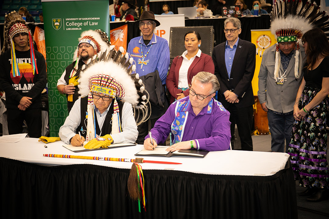 Vice-chief Dutch Lerat and Dean of Law Martin Phillipson seated at a table, signing documents