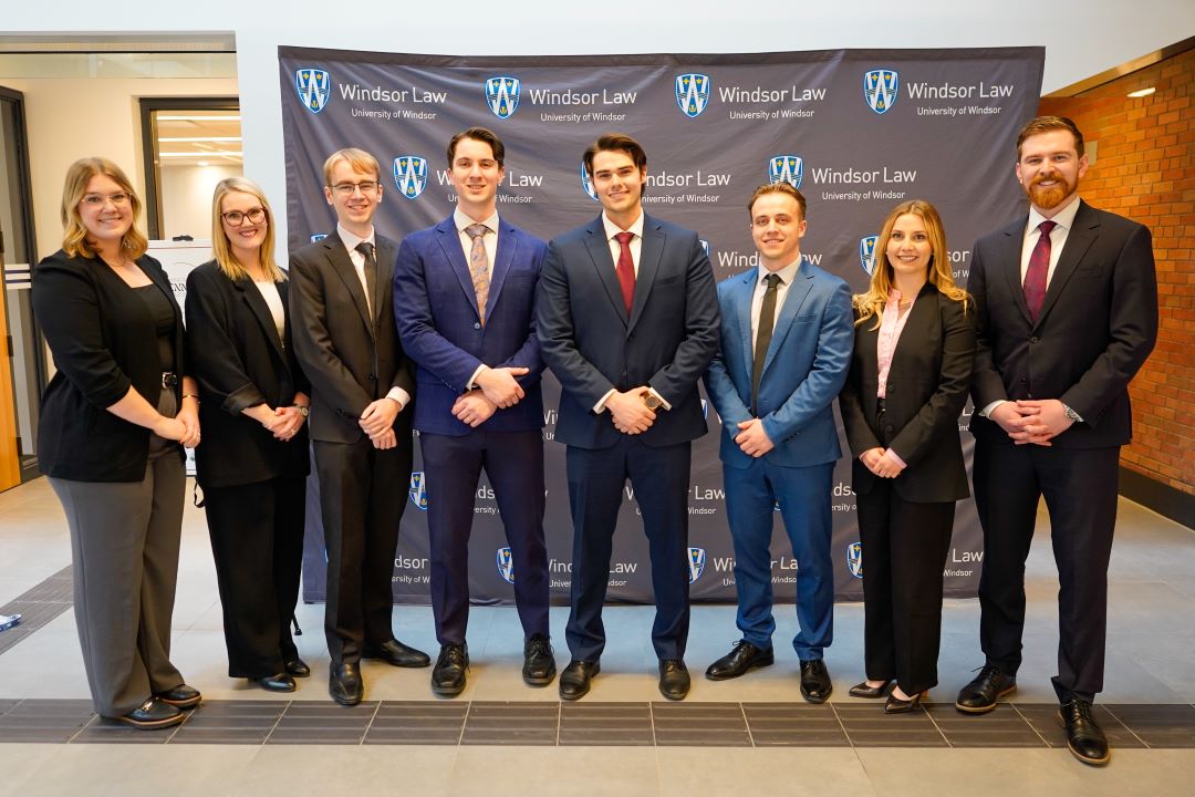 Men and women dressed in business attire posing for a group photo